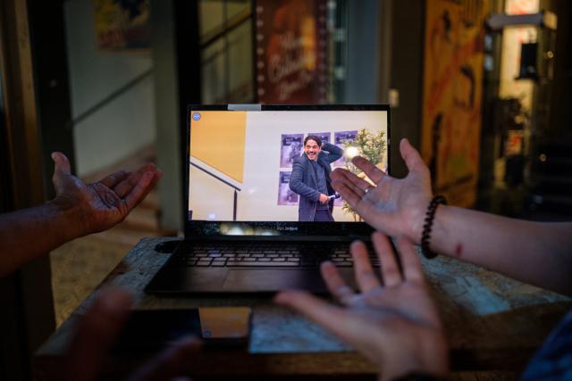 Foto von zwei Personen, die von hinten zu sehen sind und an einem Laptop-Bildschirm arbeiten.