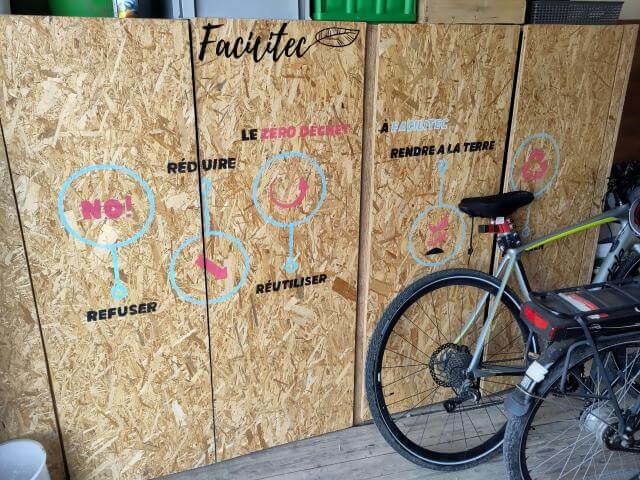 Un vélo devant un mur en bois.
