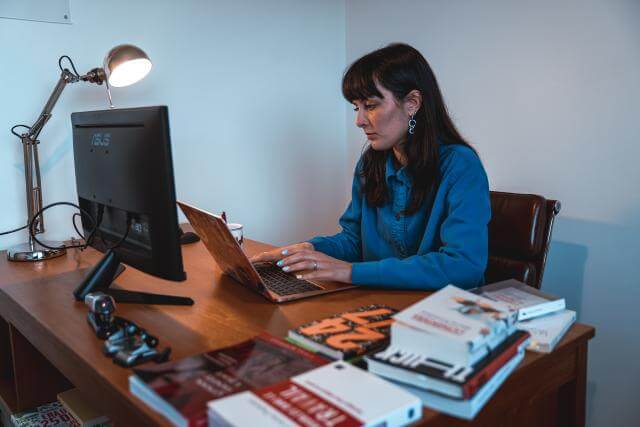 eine Frau sitzt an ihrem Computer an einem Schreibtisch
