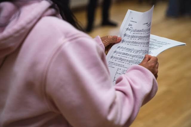 Une personne tient des feuilles avec des notes de musique