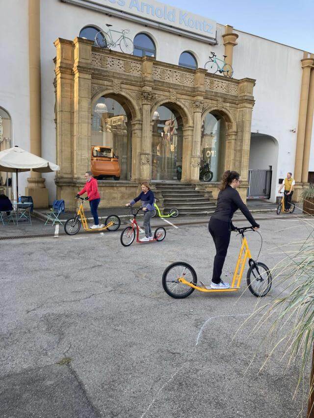 Three people on scooters.