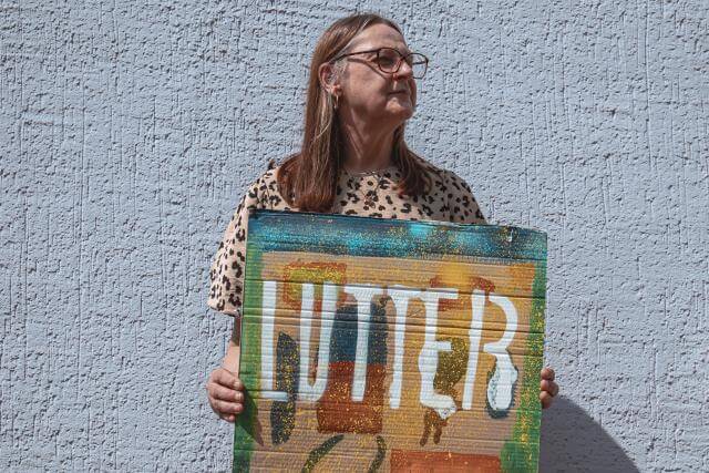 A woman holding a sign with “Fight” written on it.
