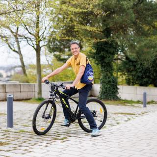 portrait de Emanuele Santi, président d’Afrilanthropy asbl. Il est à vélo.