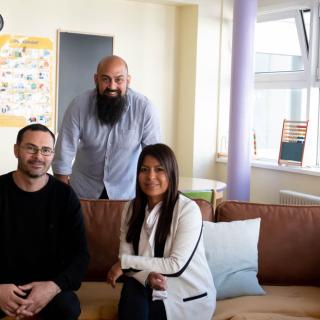 Portrait de Lisset Gabarron, assise sur un canapé avec deux de ses collègues