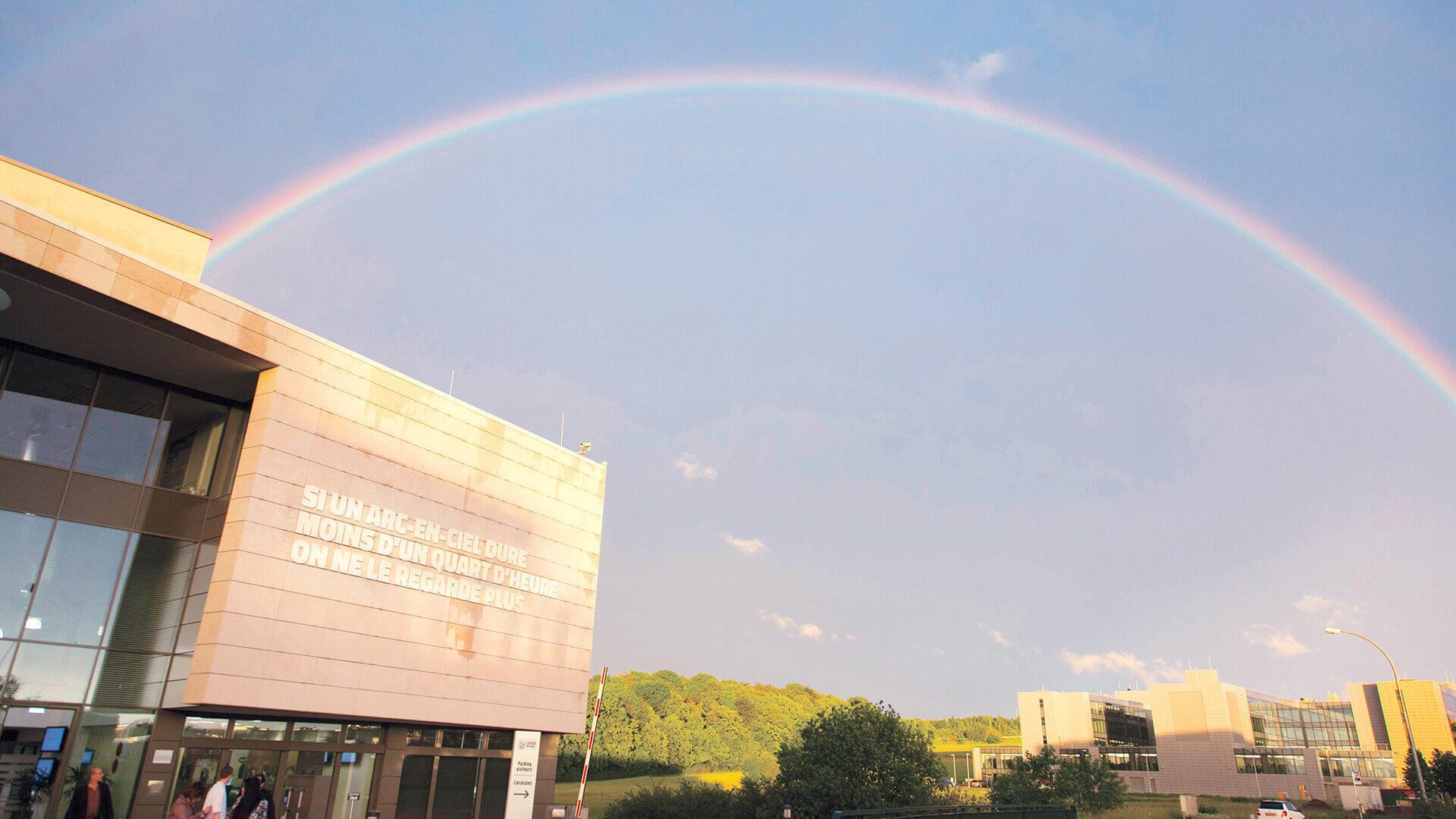 Foto des Gebäudes der Œuvre Nationale mit einem Regenbogen.