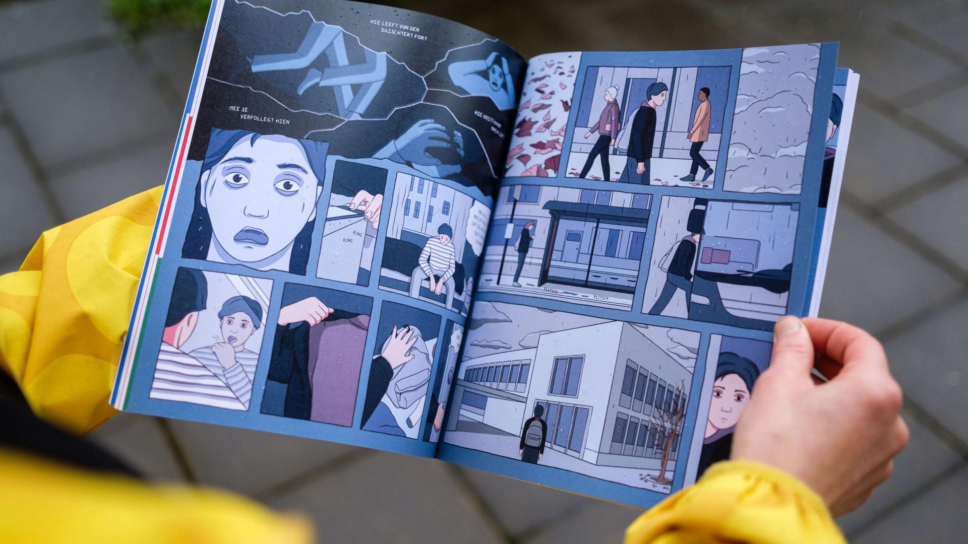 Close-up of a person's hands holding a comic book on the topic of first aid in mental health.
