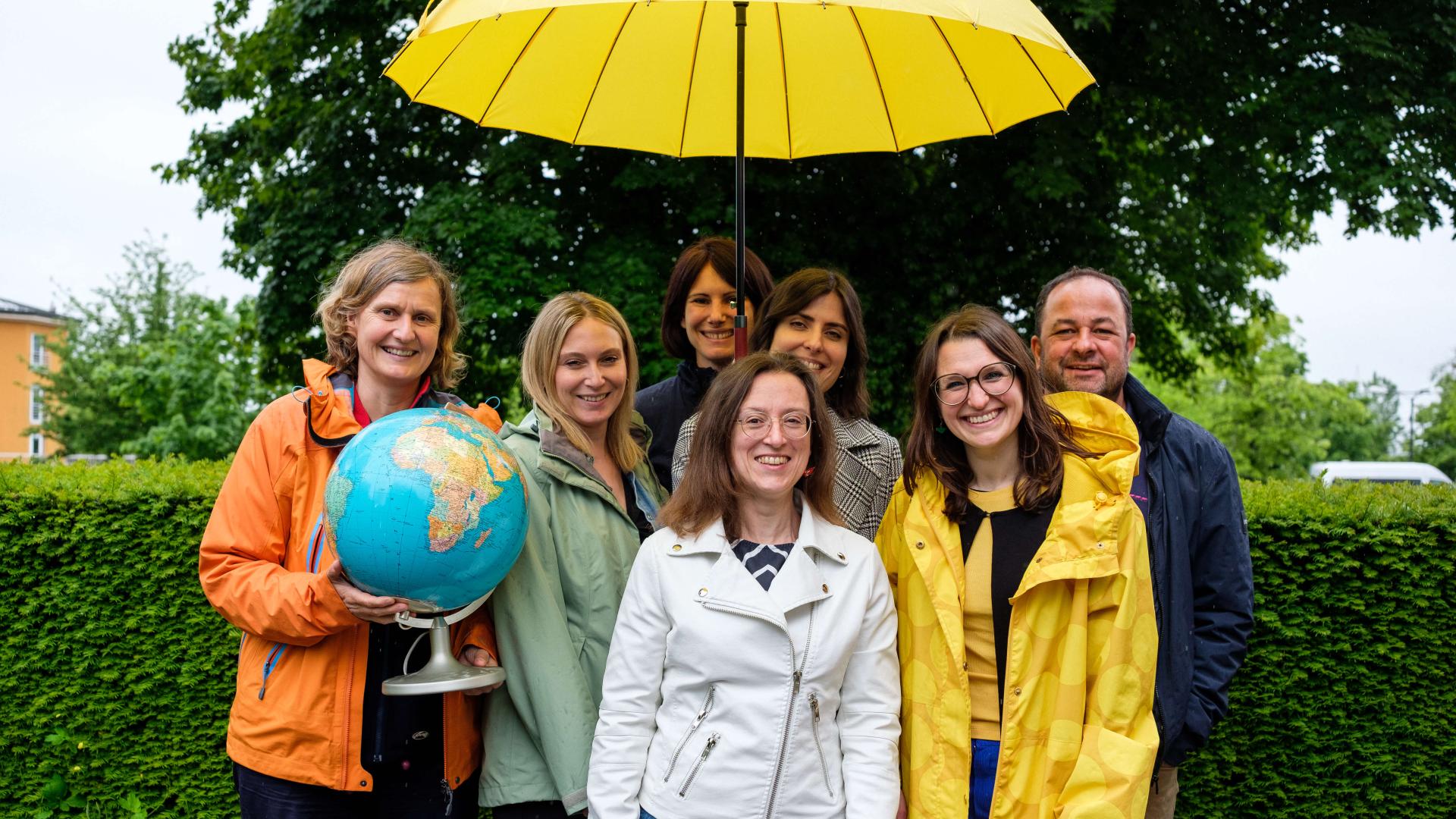 portraits de 7 personnes de l'équipe de la Ligue pour la Santé mentale avec un parapluie jaune