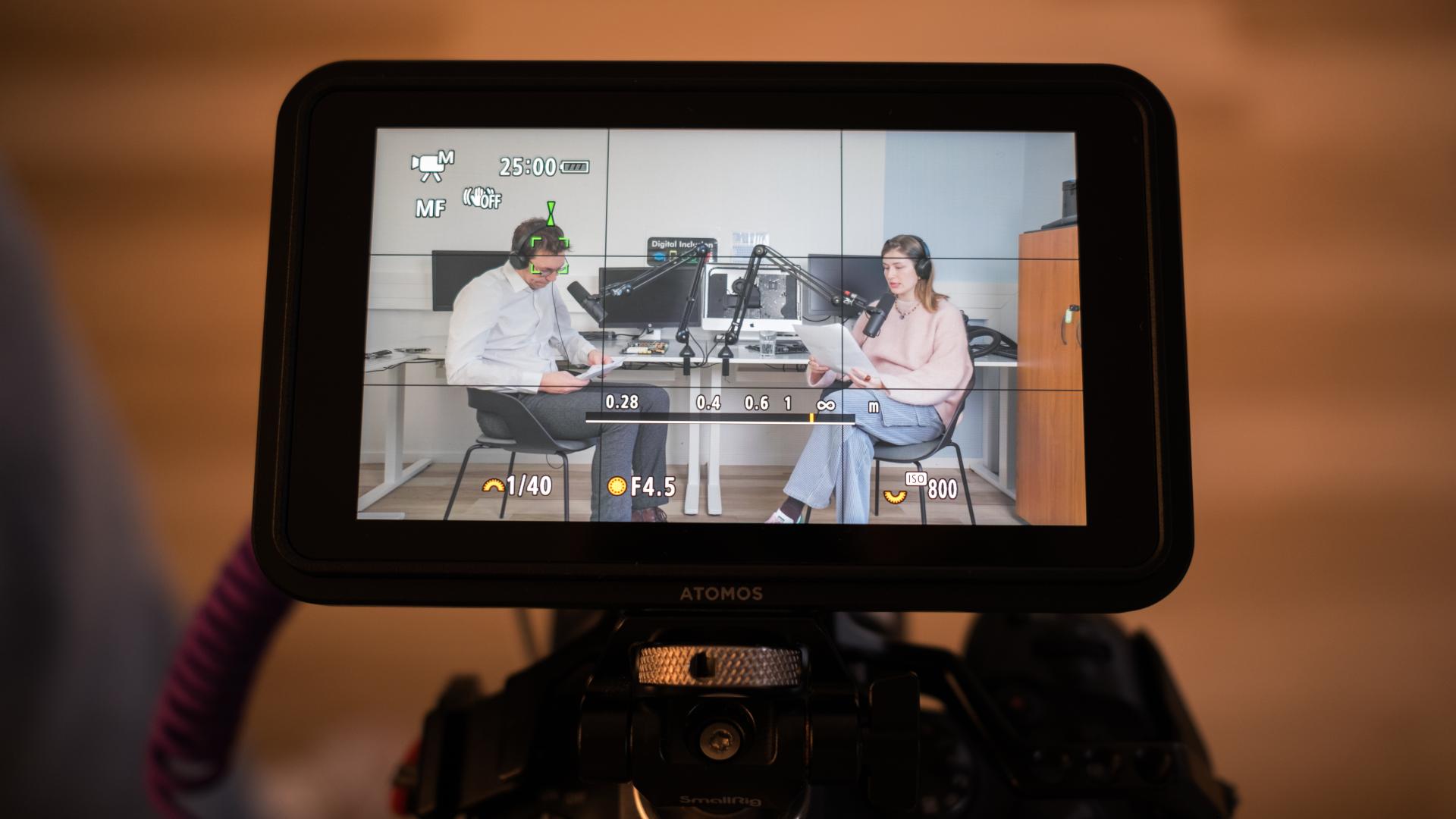 Focus on a camera recording the shooting of a podcast