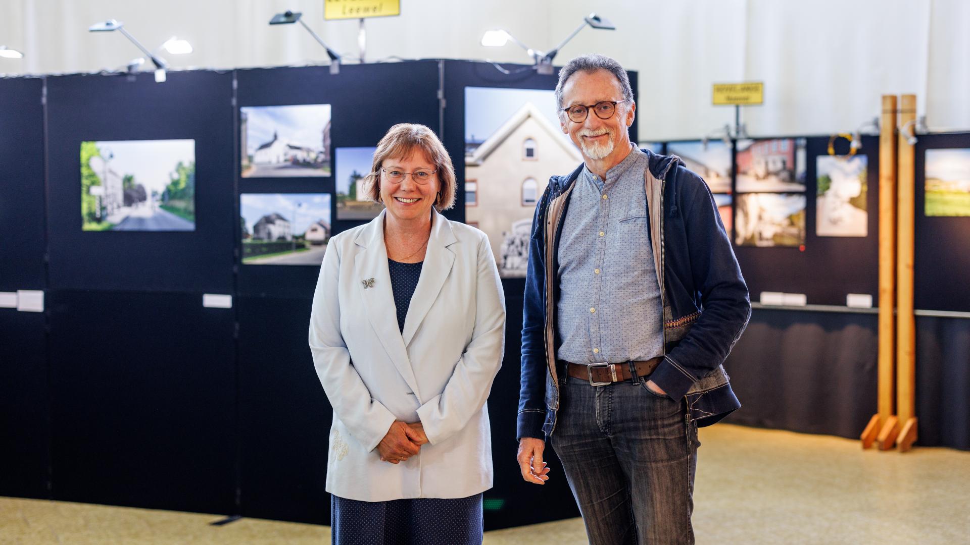 Portraits de Isabelle Bernard-Lesceux et de Philippe Malaise, devant une exposition photos