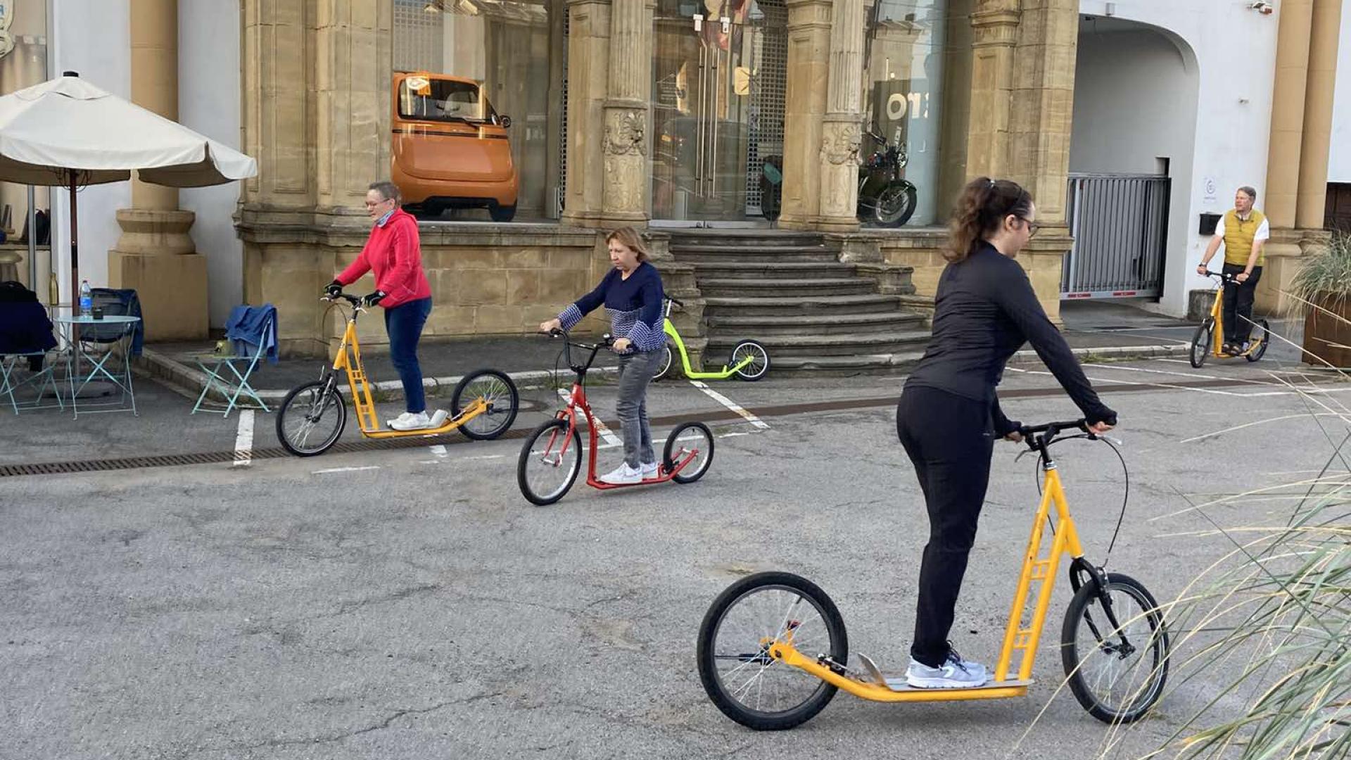 Three people on scooters.