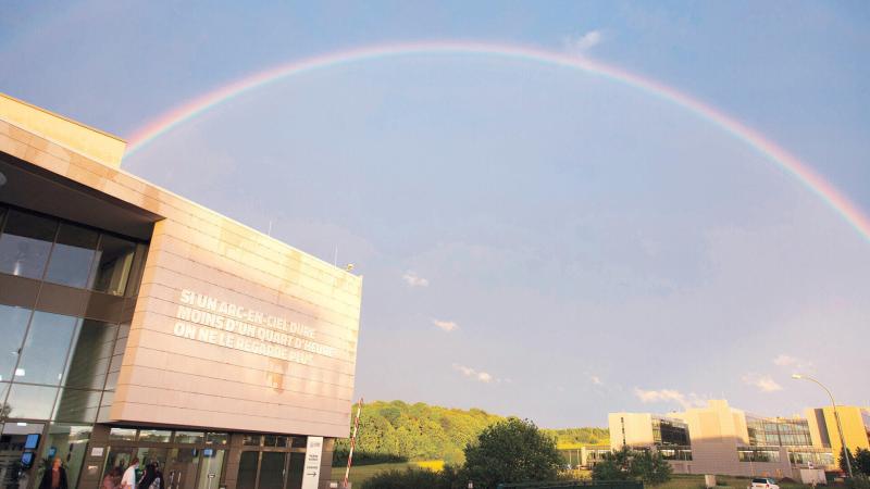 Photo du bâtiment de l'Œuvre Nationale avec un arc-en-ciel