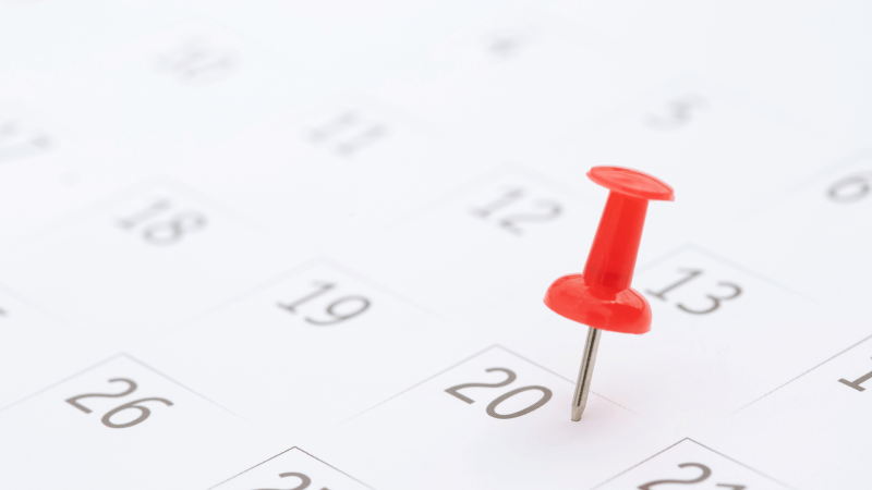 photo d'un calendrier avec une punaise rouge sur une des dates