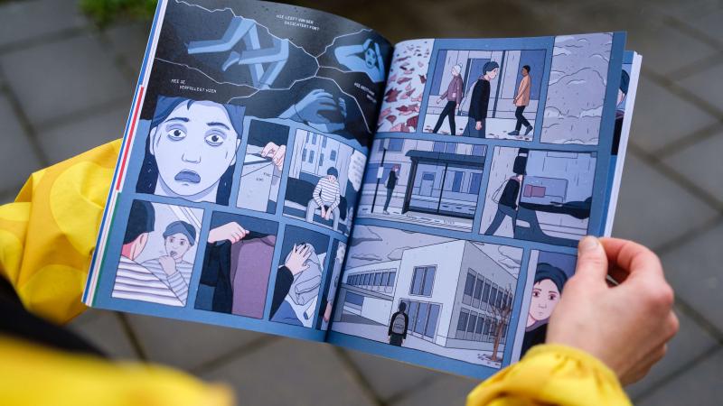 gros plan sur les mains d'une personne qui tient une bande dessinée sur le sujet des premiers secours en santé mentale