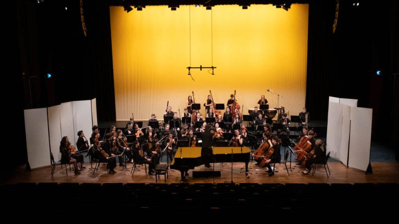 photo d'un concert de l'Orchestre National des Jeunes du Luxembourg. La scène est illuminée en jaune.