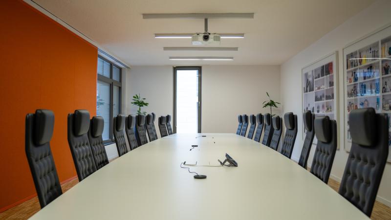 Une longue table de réunion avec des chaises de bureau autour