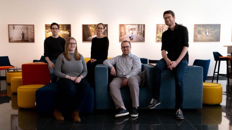 portraits de Pit Ewen et d'autres collègues de Orchestre National des Jeunes du Luxembourg. Trois hommes et deux femmes sont assis sur des fauteils colorés.
