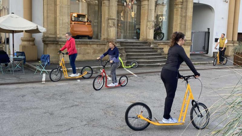 Three people on scooters.